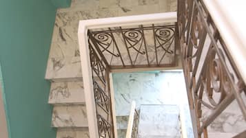 Una escalera con escalones de mármol y una pared color turquesa.