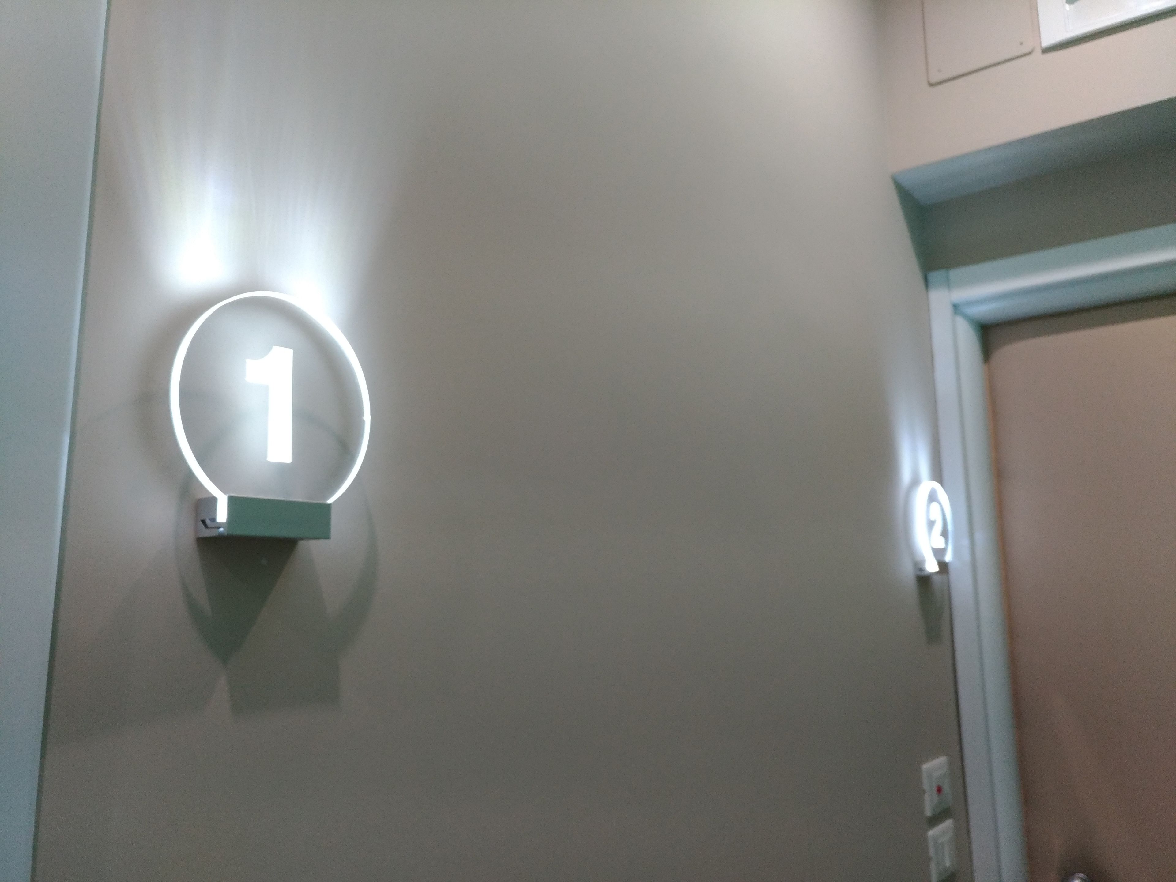 A wall-mounted circular sign with the number 1, indicating a room or location.