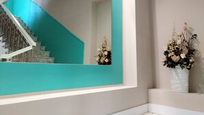 A staircase with a turquoise accent wall and a large mirror reflecting the stairs. - Domus Nova (Reggio Calabria)
