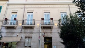 A multi-story building with balconies, a no parking sign, and a DN sign indicating a specific area or department. - Domus Nova (Reggio Calabria)