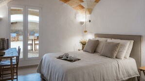 A bedroom with a bed, a breakfast tray, and a view of an outdoor patio. - Hotel Nou Sant Antoni (Ciutadella de Menorca)