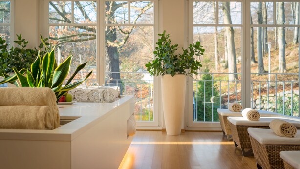 A spa area with a large window, a reception desk, and a seating area with towels. - ROEWERS Privathotel & Spa (Sellin)