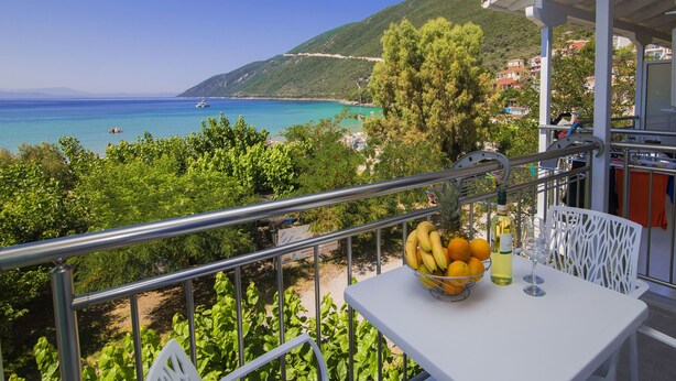 A balcony with a table, a fruit bowl, and a wine glass. - Nefeli (Lefkada)