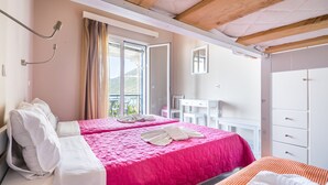 A hotel room with a bed, a desk, and a bathroom. - Nefeli (Lefkada)