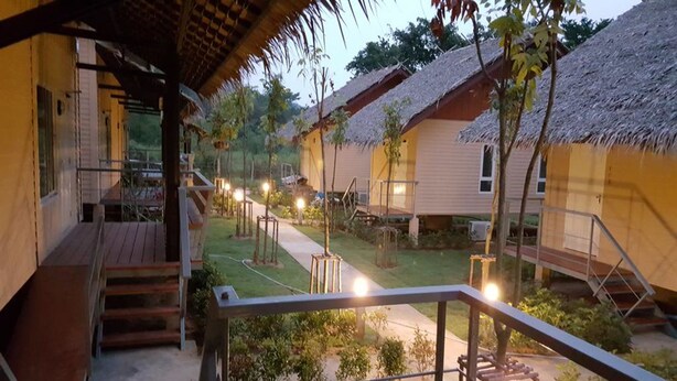 A resort with thatched-roof cabins, a central pathway, and a well-maintained garden. - Narinfah Resort (Kaeng Krachan)
