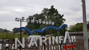 A sign for Narinthah Resort with a wooden fence and a thatched roof structure in the background. - Narinfah Resort (Kaeng Krachan)