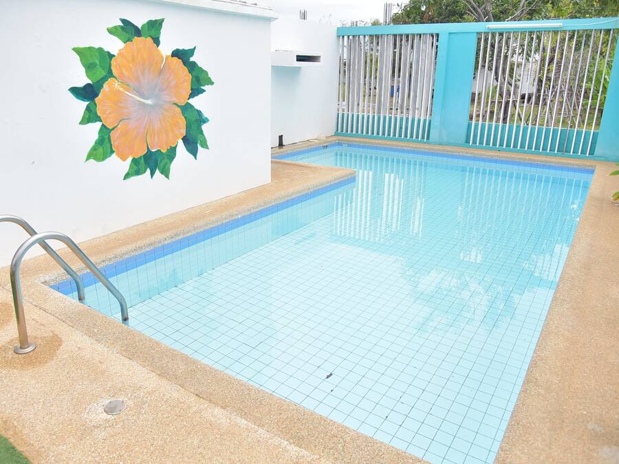 A swimming pool with a tiled floor and a metal ladder.