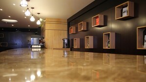 A modern lobby with a polished marble floor, wooden paneling, and pendant lighting. - AlMuhaidb Residence Al Khafji (Al Khafji)