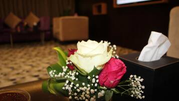 A bouquet of flowers with a tissue box on a table.