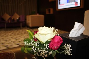 A bouquet of flowers with a tissue box on a table.
