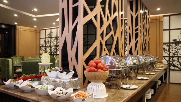 A buffet setup with various food items and a decorative wooden partition. - AlMuhaidb Residence Al Khafji (Al Khafji)