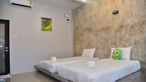 Habitación de hotel con dos camas, una plataforma de mármol, un equipo de aire acondicionado, una lámpara fijada a la pared y un pequeño dispositivo instalado en la pared.