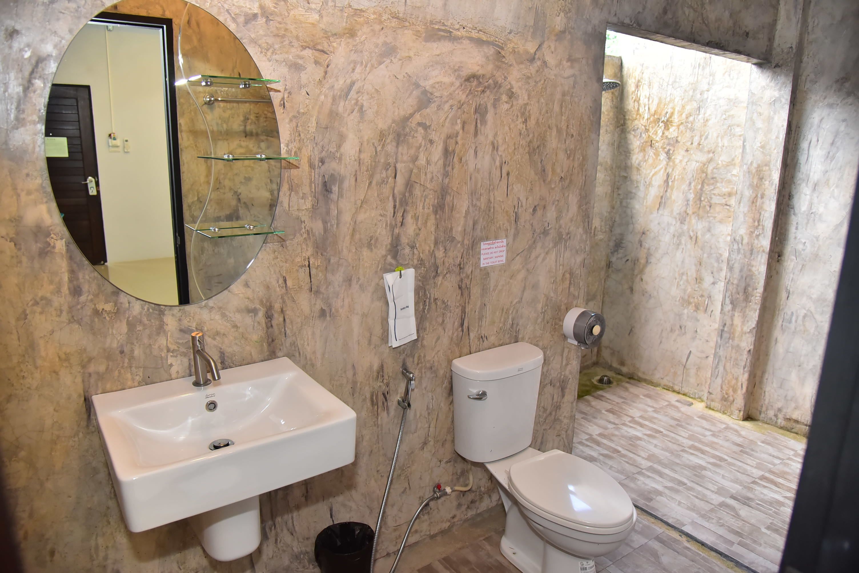 A bathroom with a white sink, a toilet, and a mirror on the wall.