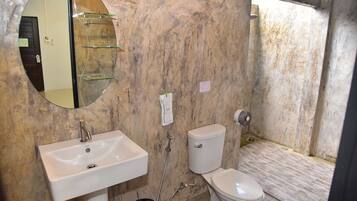A bathroom with a white sink, a toilet, and a mirror on the wall.