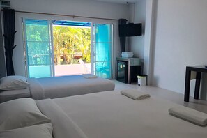Une chambre d’hôtel avec deux lits, une télévision et une vue sur l’extérieur.