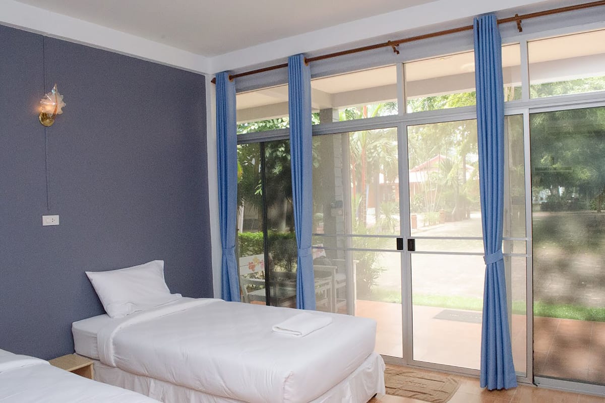 A bedroom with a bed, a nightstand, and a large sliding glass door leading to a patio.