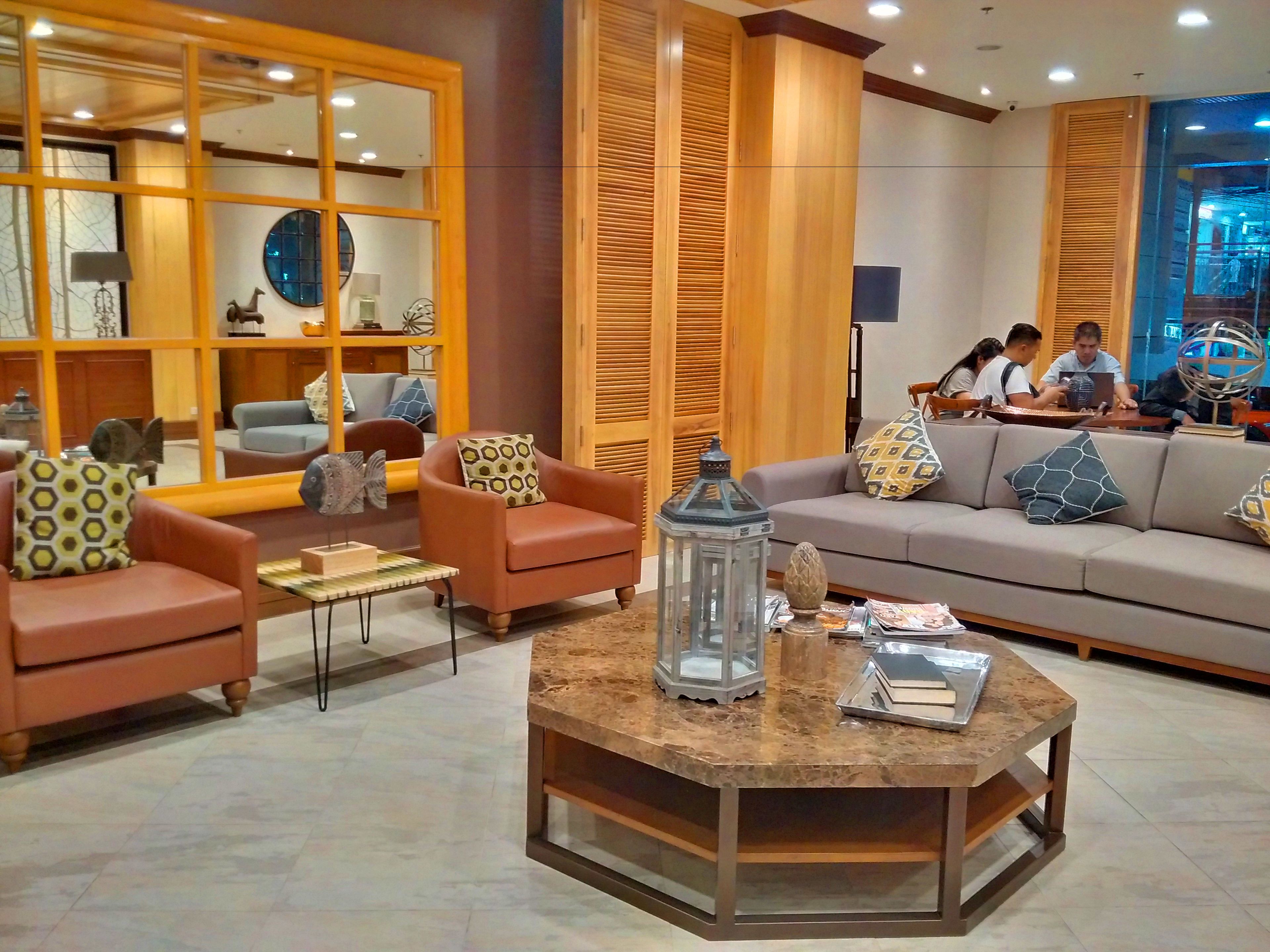 Un vestíbulo moderno con sofás de cuero, una mesa de centro y paneles de madera.