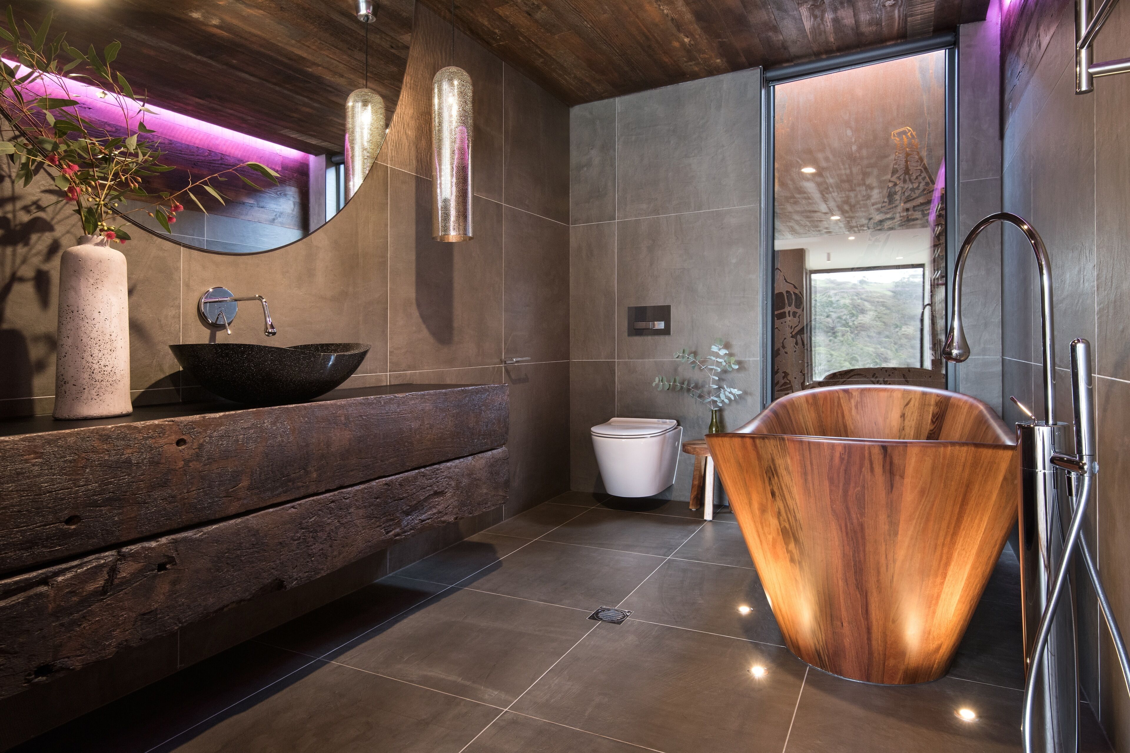 Une salle de bain moderne avec un meuble-lavabo en bois, un évier noir, une baignoire en bois et un grand miroir.