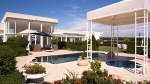 A modern house with a swimming pool, outdoor seating, and a covered patio area. - Tintagel (Metung)