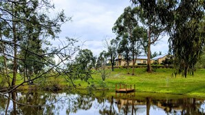 A tranquil pond with a wooden dock, surrounded by lush greenery and trees. - Avalon Private Spa Villa - Adults Only (Elevated Plains)