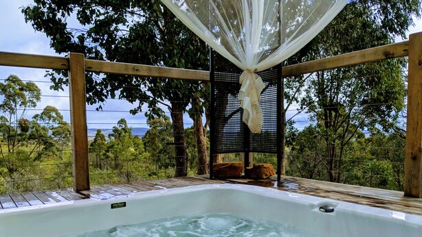 A hot tub with a view of the surrounding landscape. - Avalon Private Spa Villa - Adults Only (Elevated Plains)