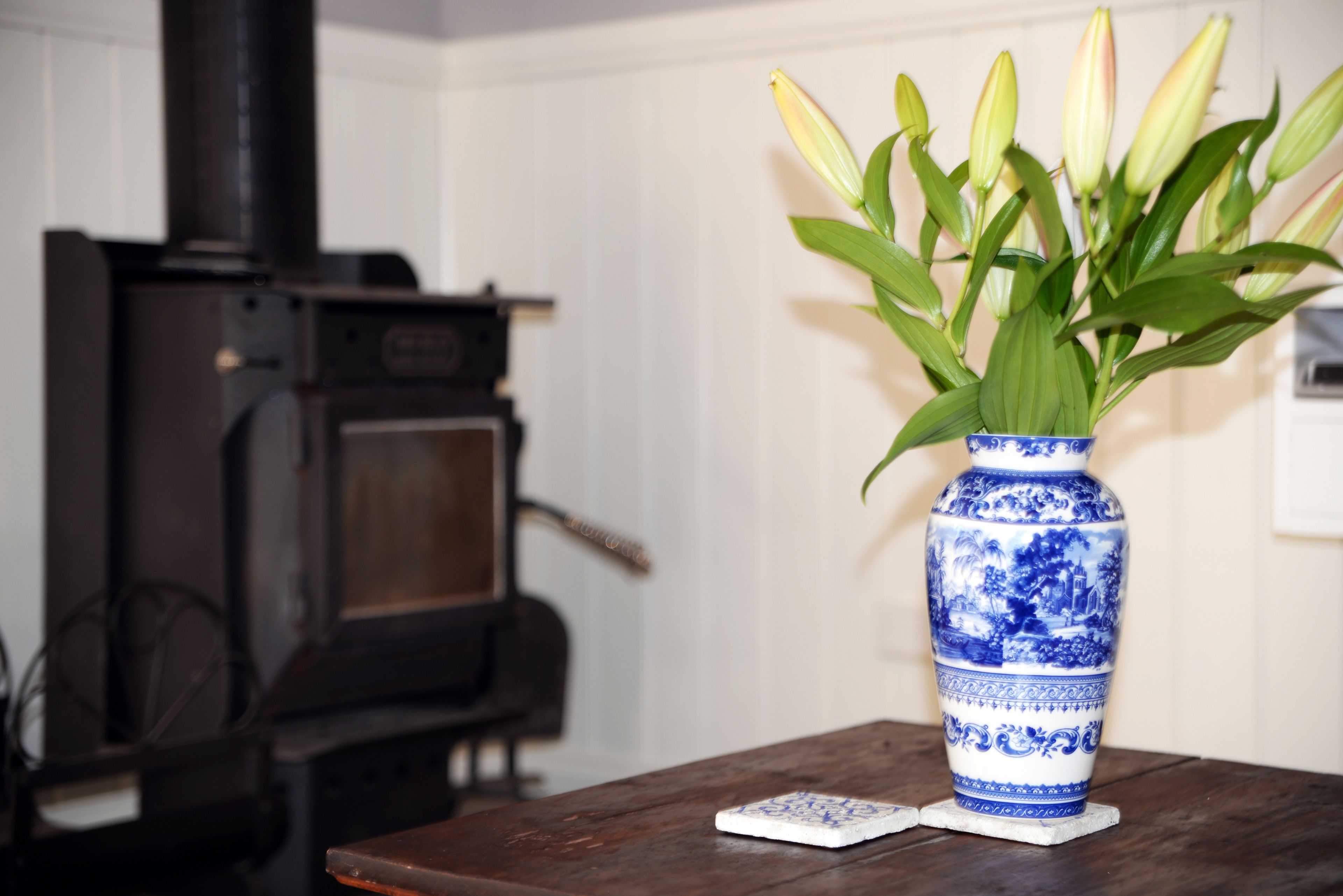 A blue and white vase with a floral arrangement on a wooden table.