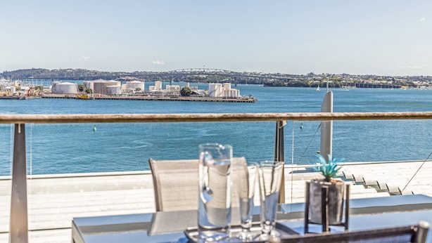 Ein Tisch mit Blick auf das Wasser und eine Brücke im Hintergrund.