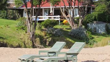 Trên bãi biển, cát trắng, ghế dài tắm nắng, dù trên bãi biển