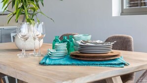 A dining table set with plates, glasses, and a vase with a plant. - Villa Lanta at Comoon Boutique Villas (Koh Samui)