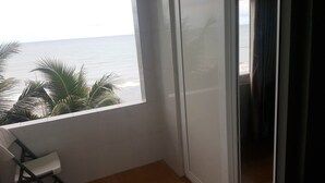 Un balcón con vista al océano y palmeras.