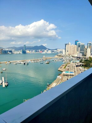 A marina with boats, a bridge, and a cityscape with tall buildings. - L’etoile de Mer (Hong Kong)