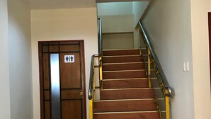 Un escalier doté d’une rampe métallique et d’un plancher en bois, menant à un niveau supérieur.