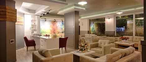 Una sala moderna con sofás, una mesa de centro y una zona de cocina con un mural colorido.