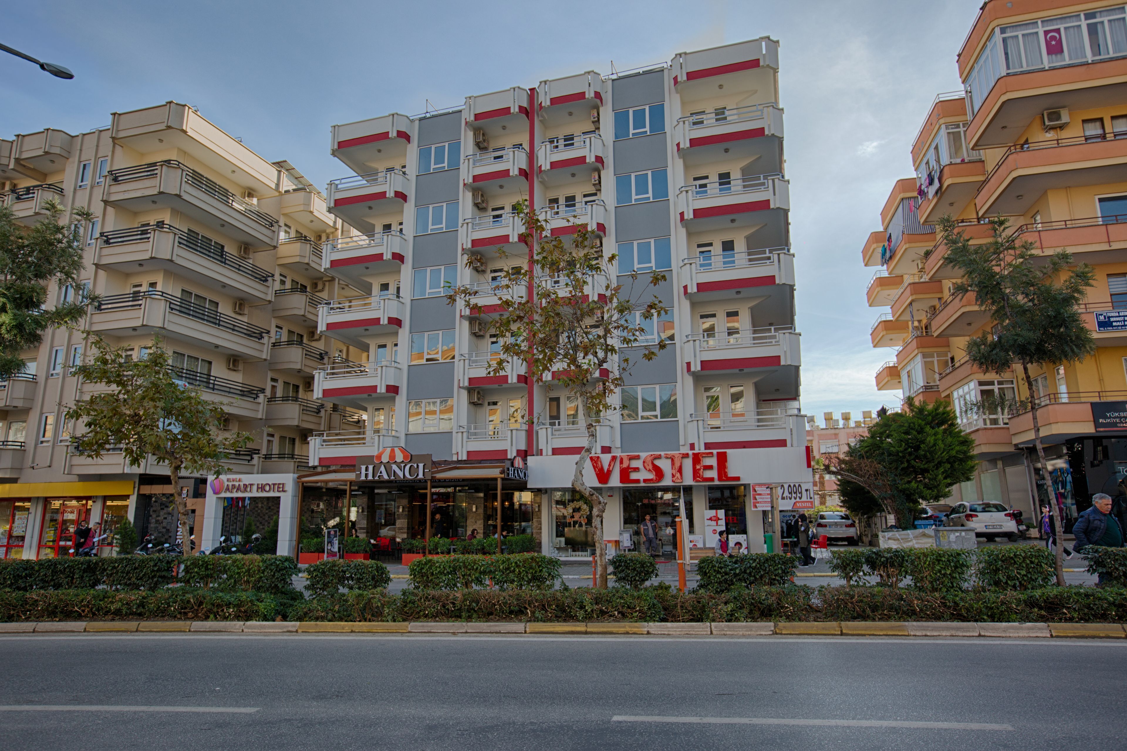 Un hotel de varios pisos con balcones, un letrero visible de 'VESTEL' y un letrero de 'HANC'.