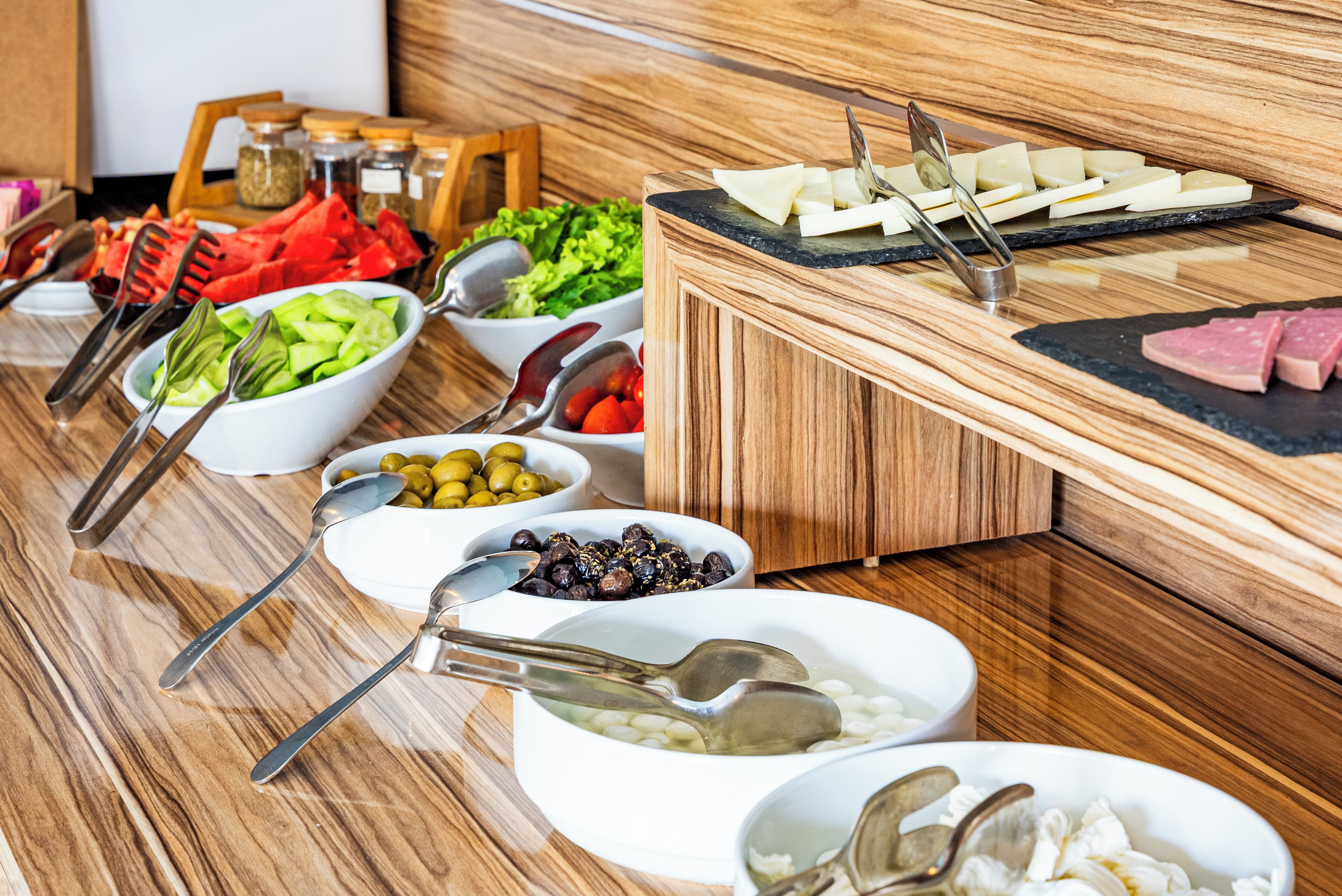 A buffet setup with various food items and utensils.