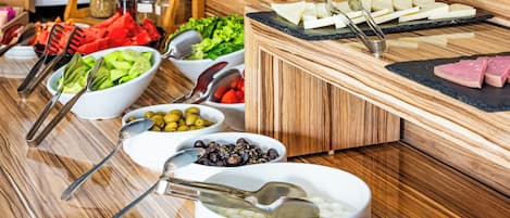 A buffet setup with various food items and utensils.