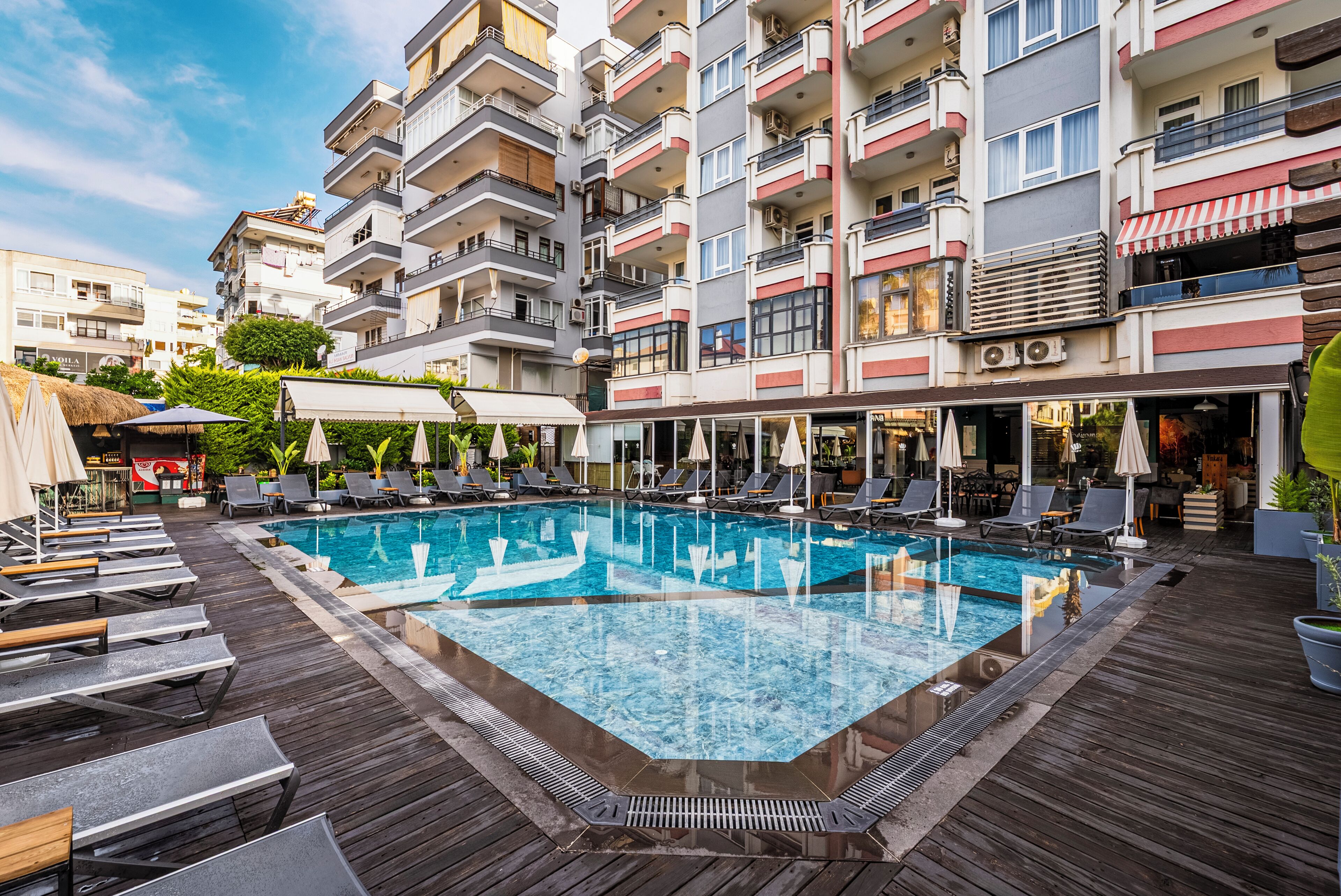 A rooftop pool area with lounge chairs and a swimming pool.