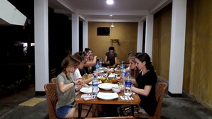 A group of people dining at a table with various dishes and drinks. - Eagle Safari Family Bungalow Udawalwe (Udawalawa)