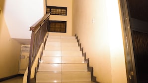 A staircase with wooden railings and a handrail, leading to an upper floor. - Jenos Hotels (Accra)