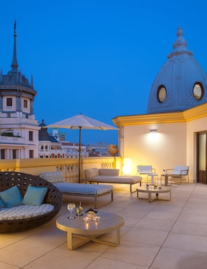 A rooftop terrace with outdoor seating, a table, and a lamp. - Sardinero Madrid (Madrid)