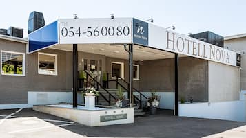 Hotel Nova's modern entrance welcomes guests with a sleek design and lush greenery.