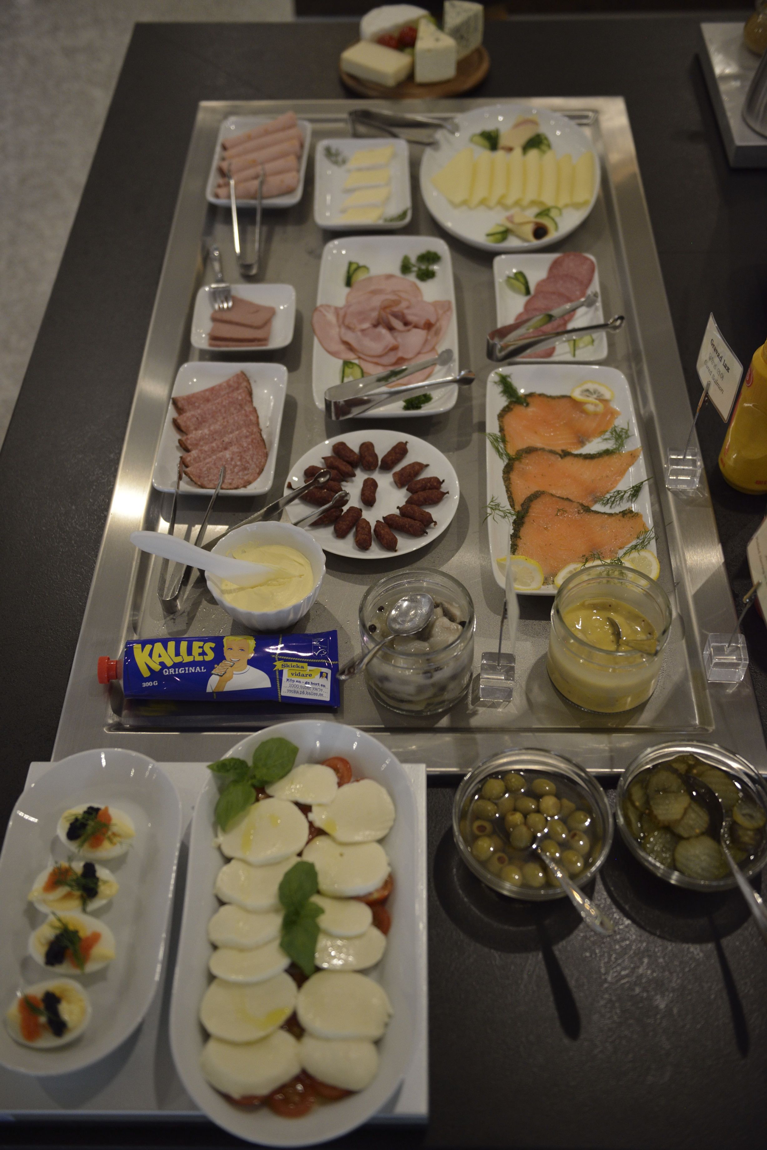 A buffet with various food items including meats, cheeses, and olives.
