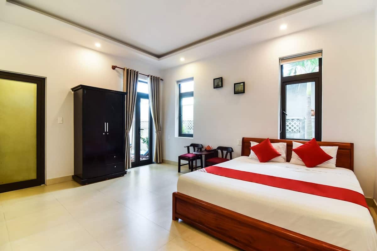 Una habitación de hotel con una cama, un armario, un escritorio y una silla.