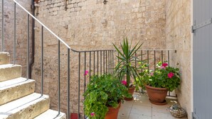 A stone staircase with metal railings, potted plants, and a door on the right. - Vila Mama (Omis)
