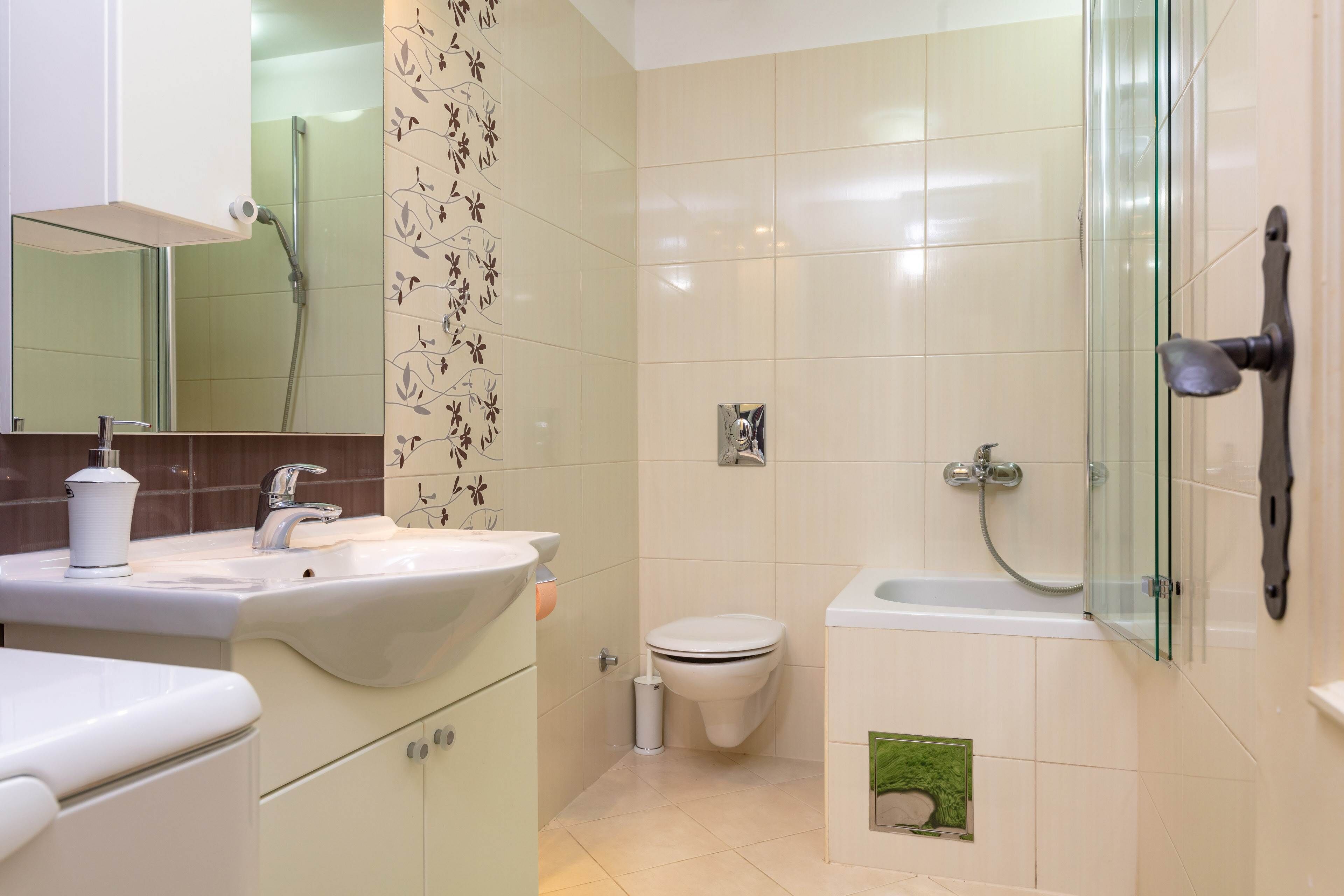 Een moderne badkamer met een wastafel, toilet en douche.