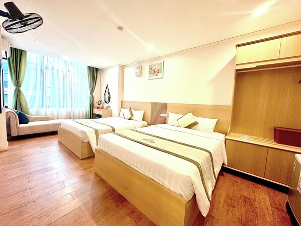 A modern hotel room with a large bed, a sofa, a desk, and a wardrobe. - Royal Hotel (Hanoi)