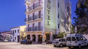 A multi-story hotel with balconies, a sign reading "HOTEL," and a parked van labeled "SERVIZI SOCIALI." - Hotel Villa Rosa (Sarroch)
