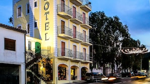 A multi-story hotel with balconies and a neon sign. - Hotel Villa Rosa (Sarroch)