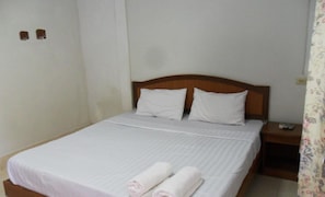 A single-bed room with a wooden headboard, white bedding, and two rolled towels on the bed. - Aonang SR Bungalow (Krabi)