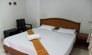 A single bed with a wooden headboard, white bedding, and a brown decorative pillow. - Aonang SR Bungalow (Krabi)